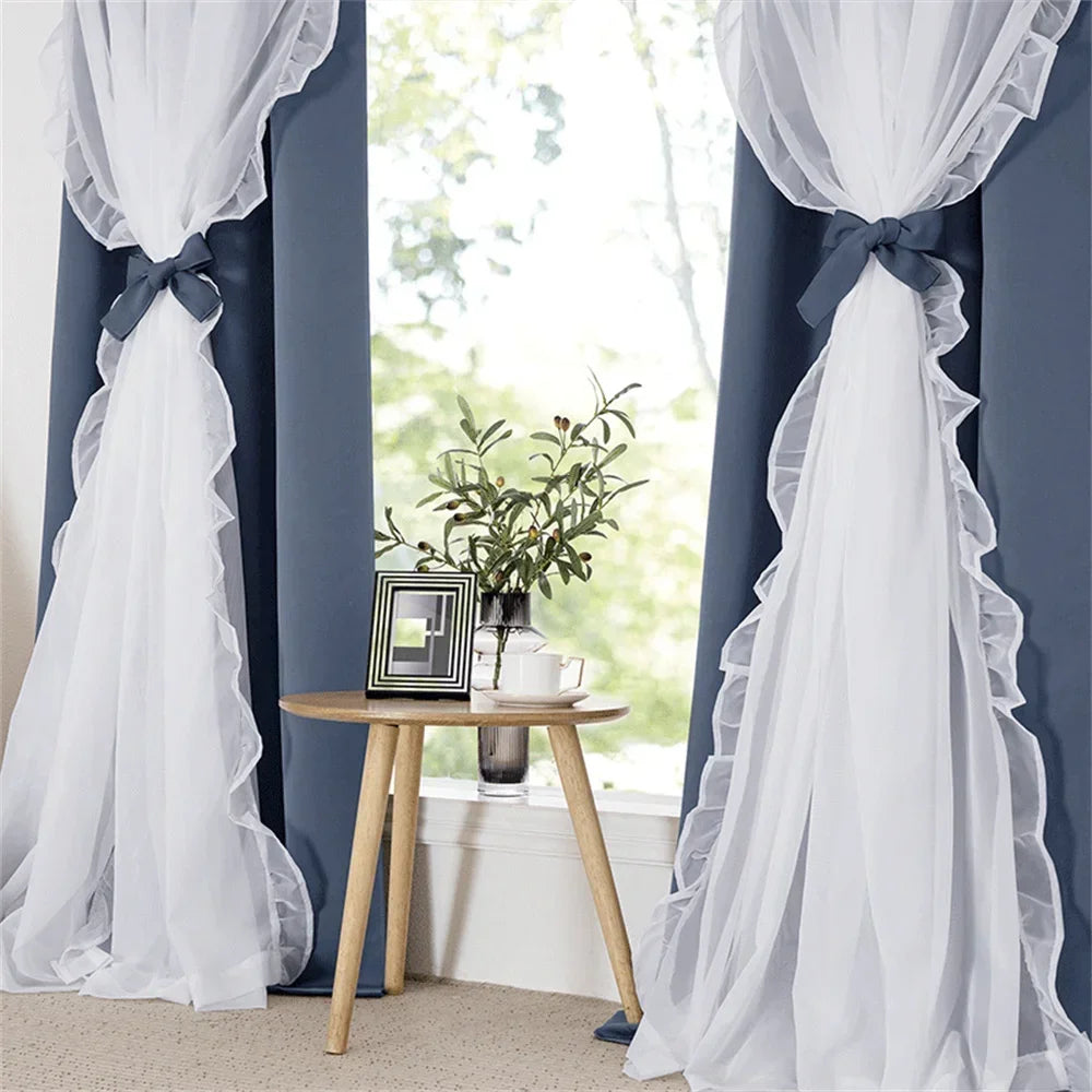 Rideaux élégants bleu foncé avec voilages blancs décoratifs et nœuds, encadrant une fenêtre lumineuse. Design parfait pour ajouter une touche chic et moderne à votre salon ou chambre à coucher. Les rideaux encadrent joliment une petite table ronde en bois, mettant en valeur une plante verte et une photo, créant une ambiance chaleureuse et accueillante. Idéal pour améliorer l’esthétique et l’intimité de votre intérieur.
