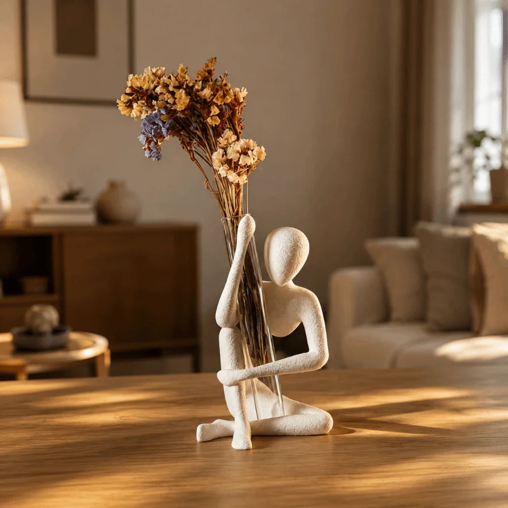 statue humaine assise vase transparent fleurs séchées moderne sculpture décorative textures granuleuses meubles bois