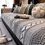 Lit douillet douillet avec couverture en motifs géométriques noirs et blancs, oreillers moelleux et plateau de décoration sur le lit.