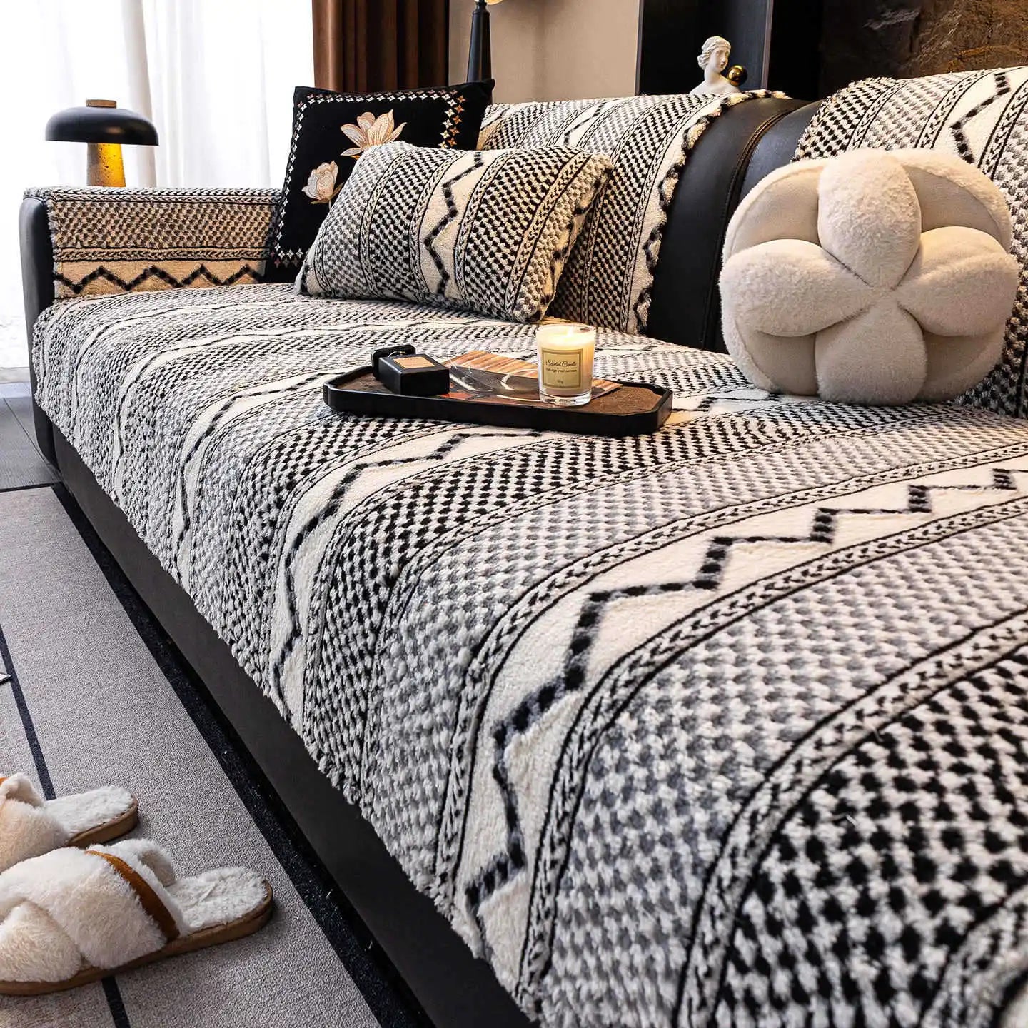 Lit douillet douillet avec couverture en motifs géométriques noirs et blancs, oreillers moelleux et plateau de décoration sur le lit.