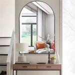 Une zone d'entrée élégante avec un miroir rond, un meuble de rangement en bois et des décorations modernes, créant une atmosphère accueillante et raffinée.
