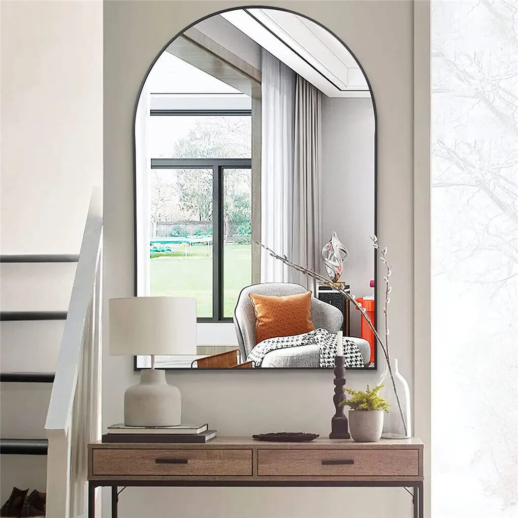 Une zone d'entrée élégante avec un miroir rond, un meuble de rangement en bois et des décorations modernes, créant une atmosphère accueillante et raffinée.