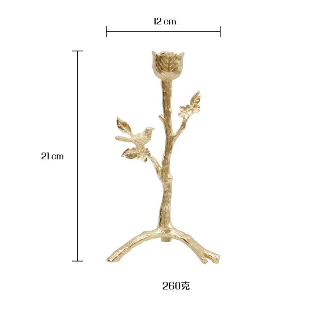 Une branche décorative dorée avec des formes de feuilles et d'oiseaux, mesurant 21 cm de hauteur et 12 cm de largeur.