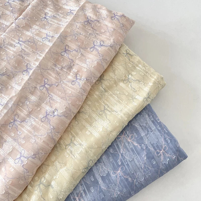 tissu polyester coton rose clair beige bleu clair motif nœuds fleurs élégant romantique 150cm