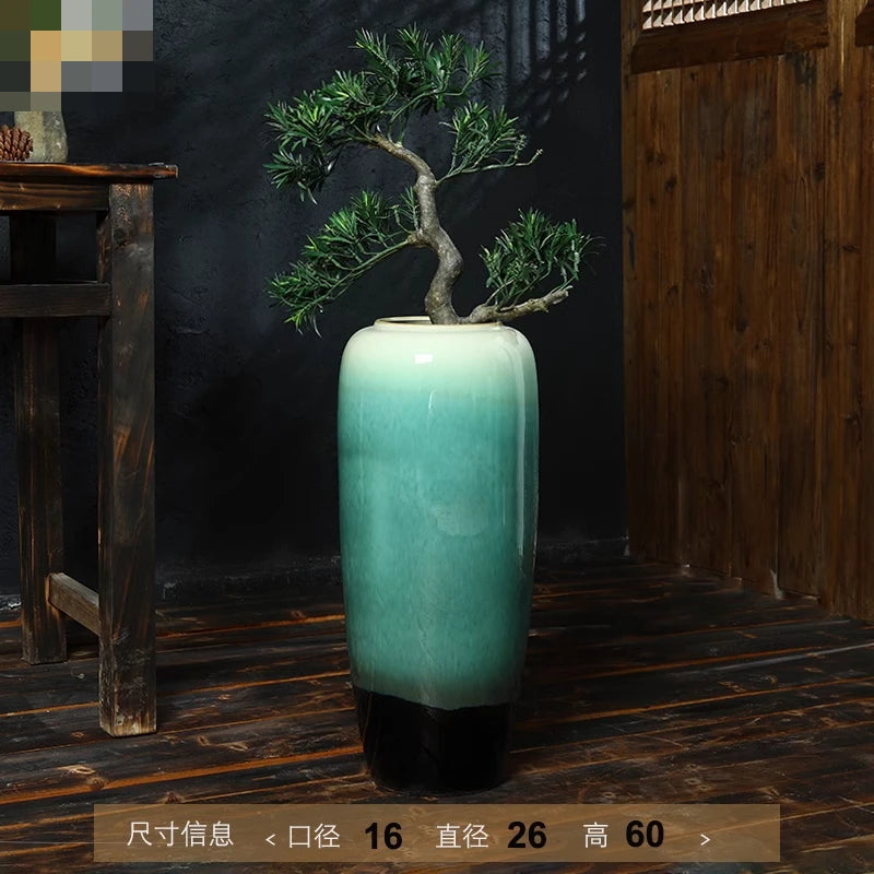 Magnifique vase en céramique de couleur verte posé sur une étagère en bois, avec un bonsaï décoratif à l'intérieur.