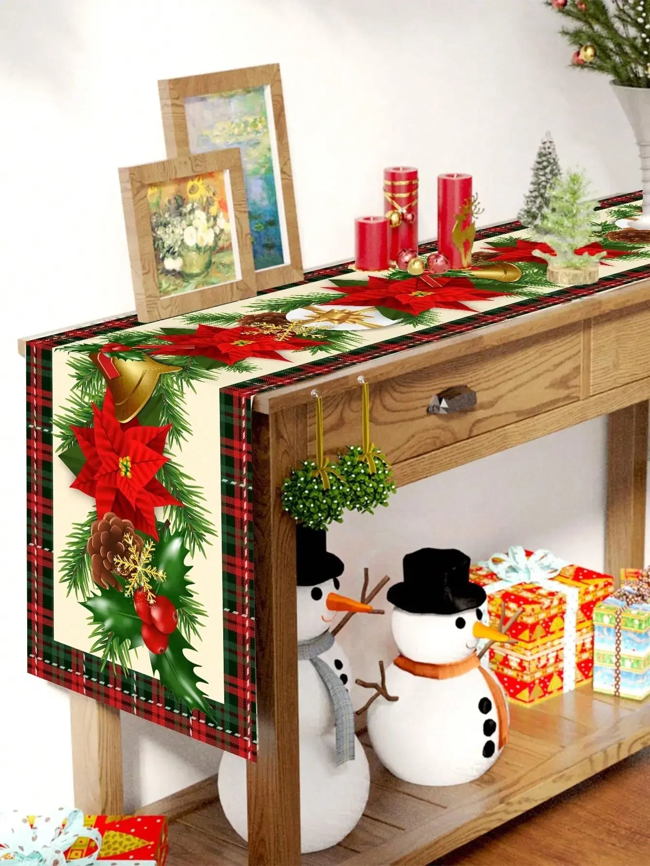 Un décor de Noël magnifique avec des décorations florales, des bougies rouges, des figurines de bonhomme de neige et des cadeaux, sur une étagère en bois, créant une ambiance festive et chaleureuse.