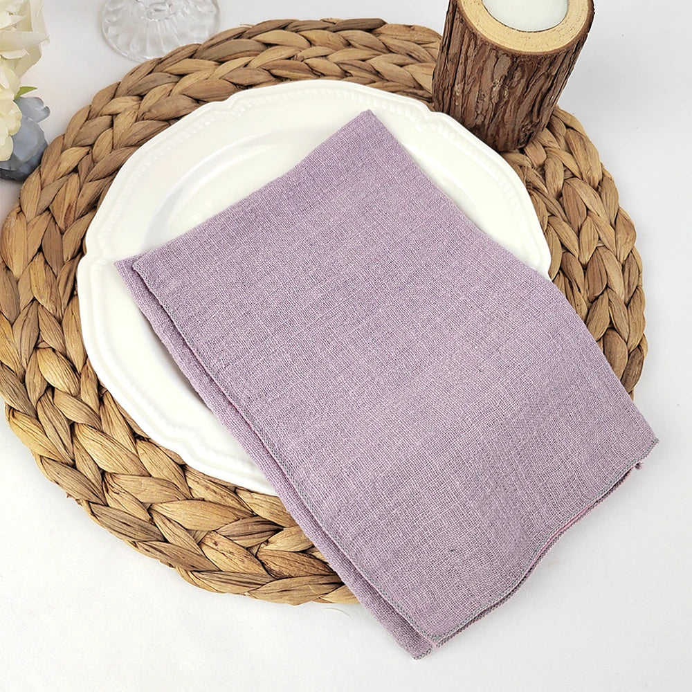 Un set de table en fibres tressées naturelles accueille une assiette blanche et un linge de table mauve.