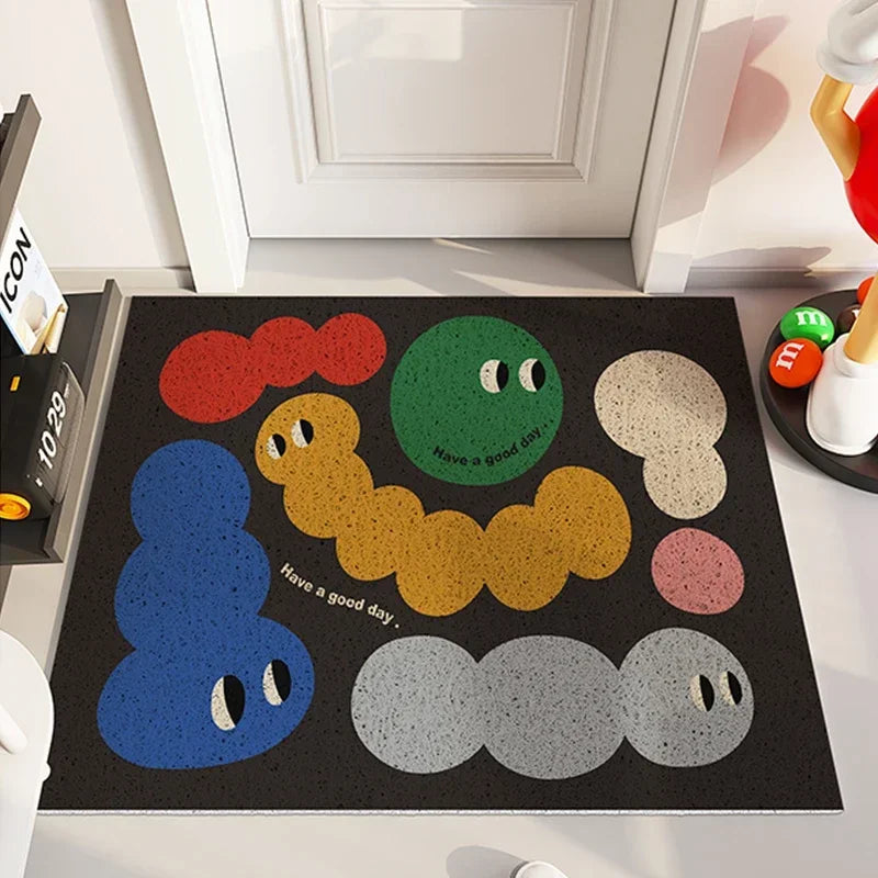 Un tapis personnalisé avec des personnages colorés expressifs semble avoir une conception amusante et accueillante pour créer une atmosphère positive dans l'entrée de la maison.