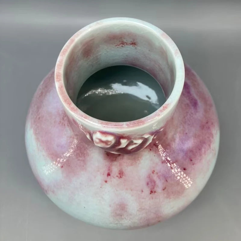 Cette tasse en porcelaine aux tons roses et verts contient un liquide sombre et mystérieux, évoquant un élixir magique.