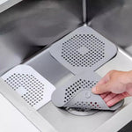 filtre bain réutilisable perforations géométriques adhésif blanc gris moderne respectueux environnement