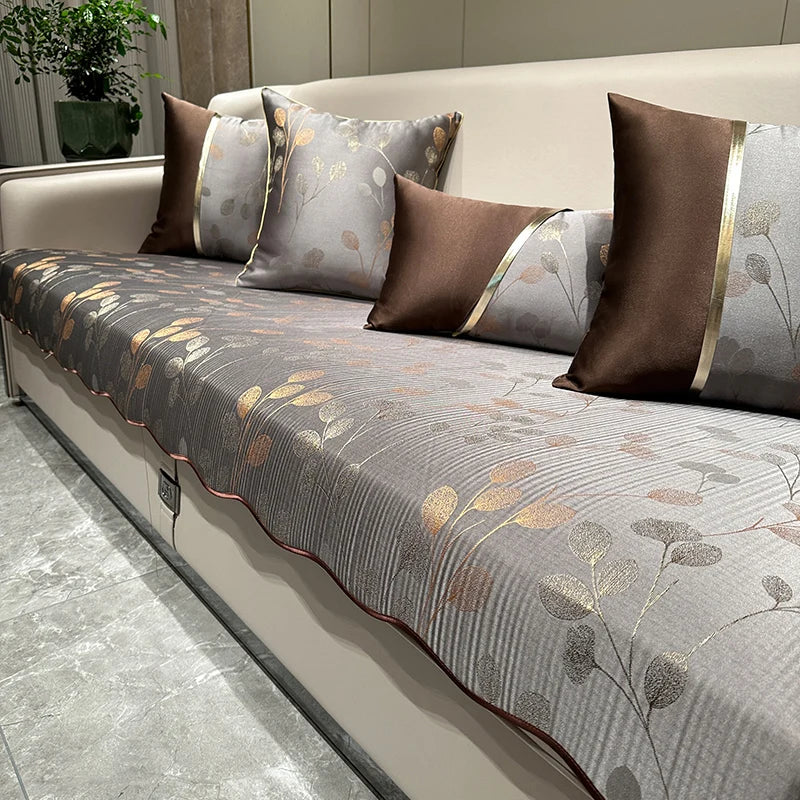 Un canapé moelleux garni de coussins et d'un plaid aux motifs floraux et de couleurs neutres, créant une ambiance chaleureuse et élégante dans la pièce.