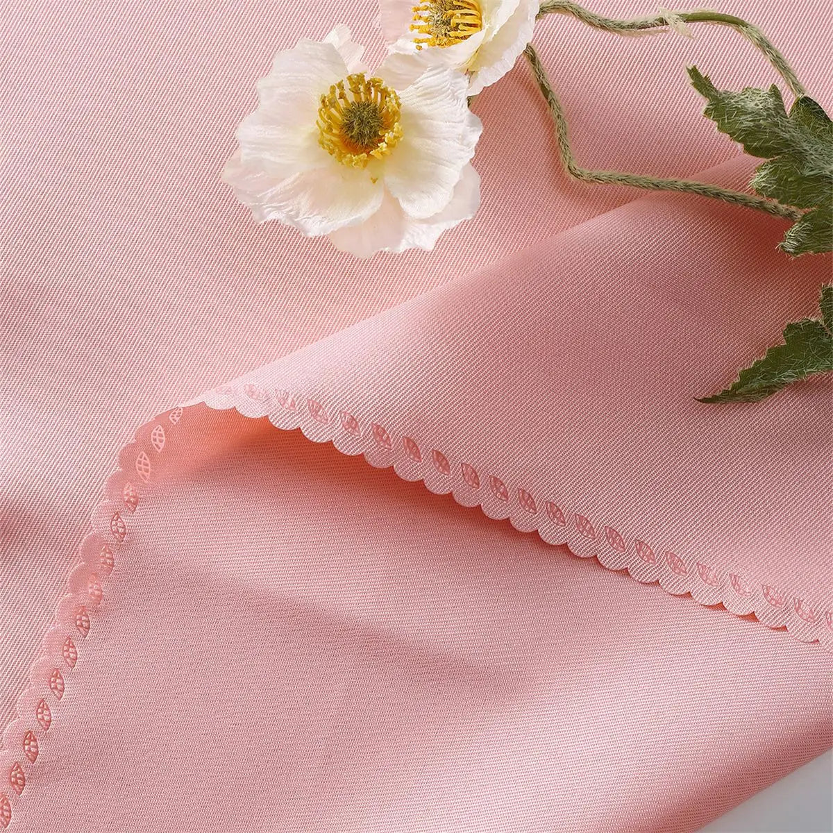 Délicate fleur blanche épanouie sur fond rose pastel avec ornement de dentelle.