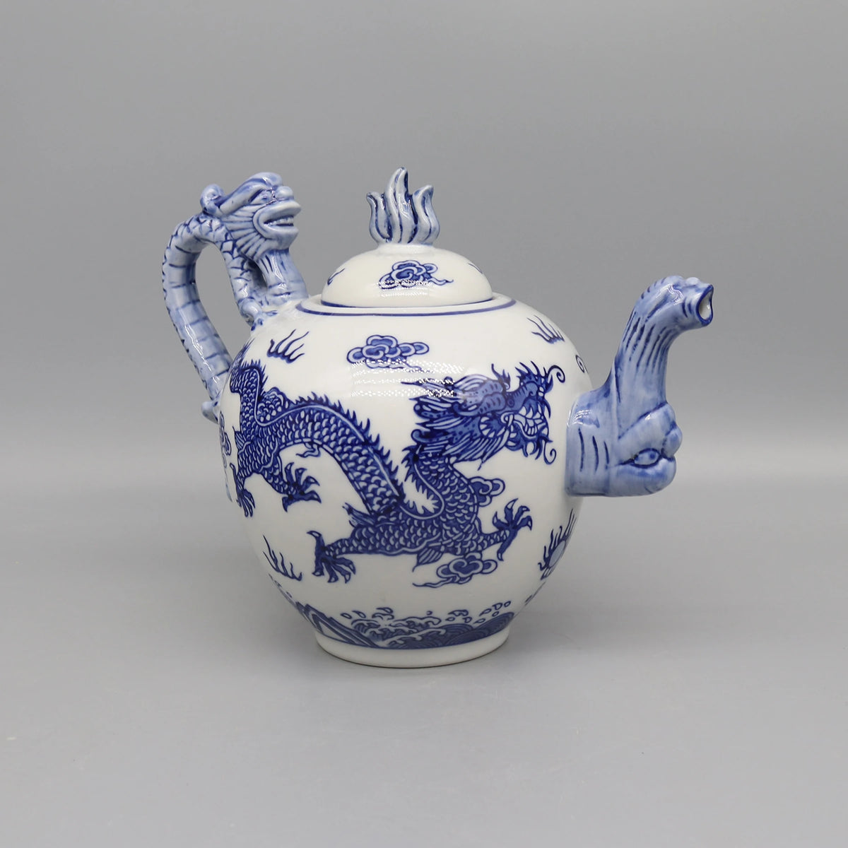 Théière en porcelaine blanche ornée de motifs bleus dragons.