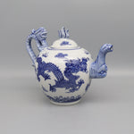 Théière en porcelaine blanche ornée de motifs bleus dragons.
