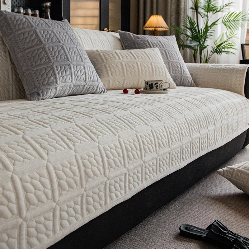 Un canapé gris matelassé avec des coussins assortis décore ce salon cosy, avec une plante verte ajoutant une touche de nature.