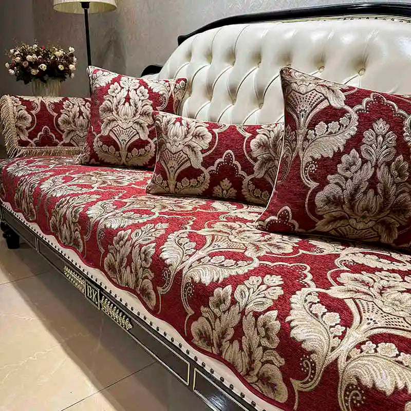 Le canapé élégant présente un motif floral baroque luxueux sur un riche fond rouge, créant une atmosphère sophistiquée et chaleureuse dans la pièce.