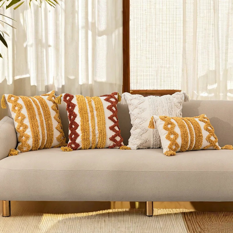 Un canapé confortable avec des coussins aux motifs géométriques chalereux dans les tons ocre et rouge.