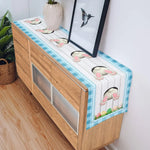 Une table de bureau décorative avec un plateau en bois et des motifs de pattes d'animaux peints dessus, entourée de plantes vertes et d'un cadre photo.