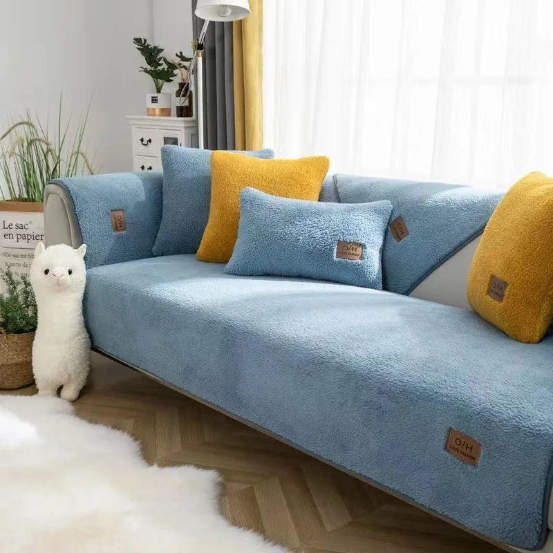 Un canapé douillet et confortable, aux coussins bleu gris et jaunes, avec un joli alpaga blanc en guise de décoration, pour créer une atmosphère chaleureuse et cocooning dans cette pièce.
