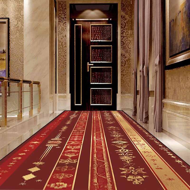 Un couloir luxueux avec un tapis décoratif en rouge et or, des murs ornés de motifs dorés et une porte en bois sombre, créant une atmosphère élégante et chaleureuse.