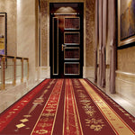 Un couloir luxueux avec un tapis décoratif en rouge et or, des murs ornés de motifs dorés et une porte en bois sombre, créant une atmosphère élégante et chaleureuse.