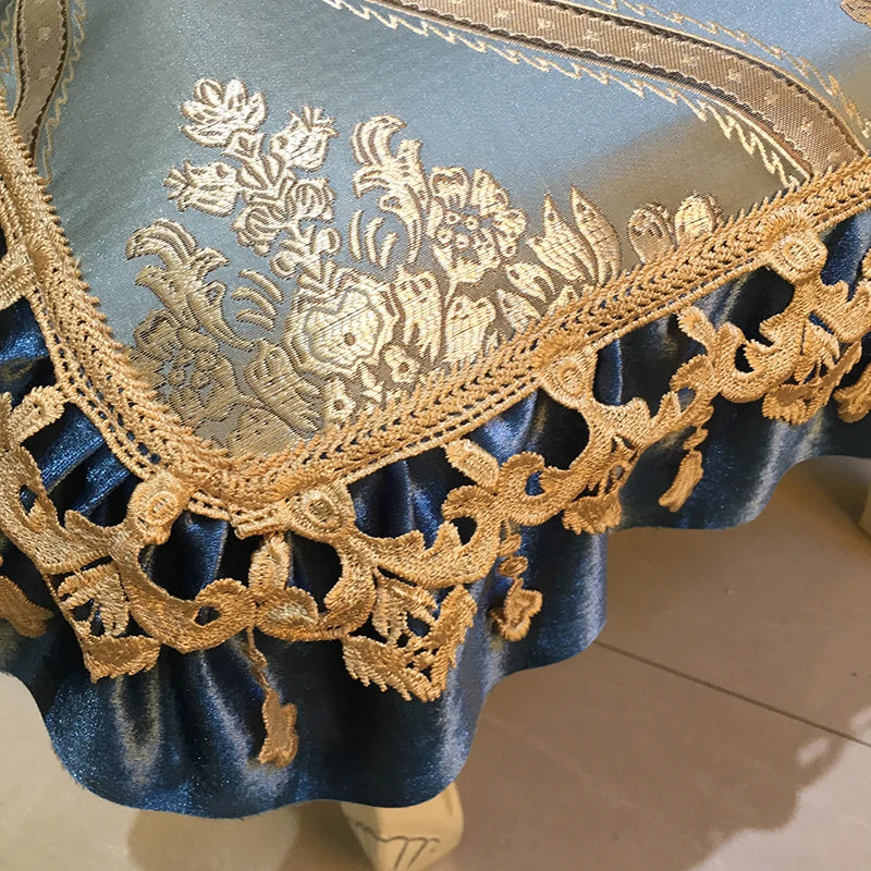 Gros plan sur un motif floral brodé sur un vêtement bleu, avec une belle bordure en dentelle dorée.
