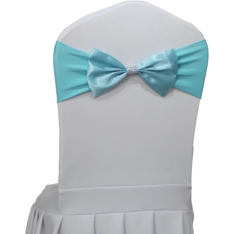 Chaise blanche avec un noeud en satin bleu turquoise décoratif et une ceinture accroché autour.