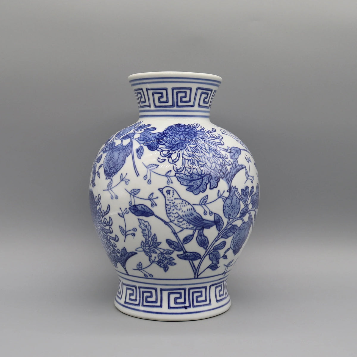 Un vase en porcelaine bleu et blanc avec un motif floral et oiseau.
