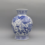 Un vase en porcelaine bleu et blanc avec un motif floral et oiseau.