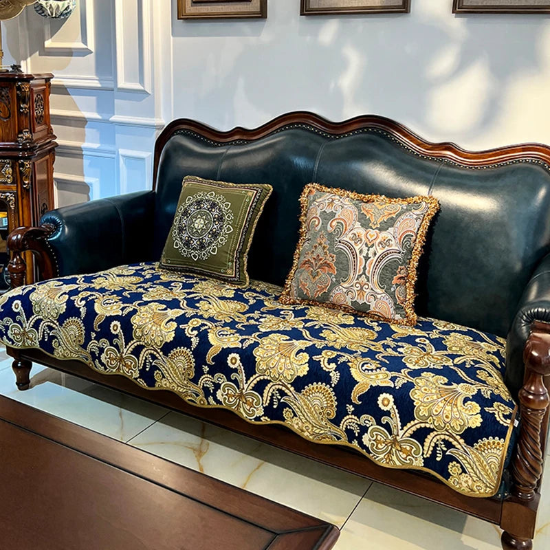 Ce canapé vintage en cuir noir avec ses coussins décoratifs aux motifs floraux dorés et foncés offre une élégance classique qui s'intègre parfaitement dans un intérieur sophistiqué.