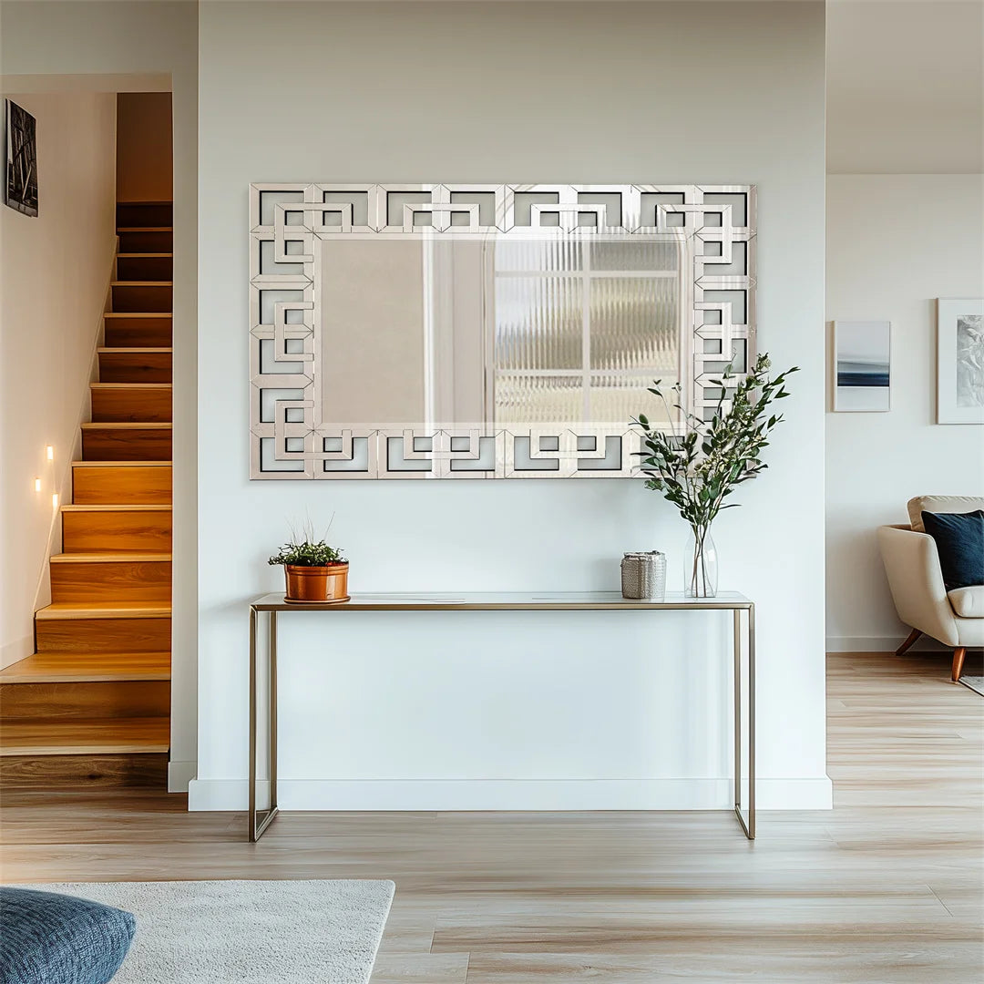 Intérieur spacieux et lumineux avec un escalier en bois, un miroir décoratif et un meuble console sobre.