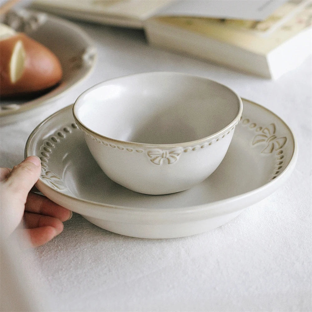 Bol et assiette en céramique blanche ornés de motifs floraux.