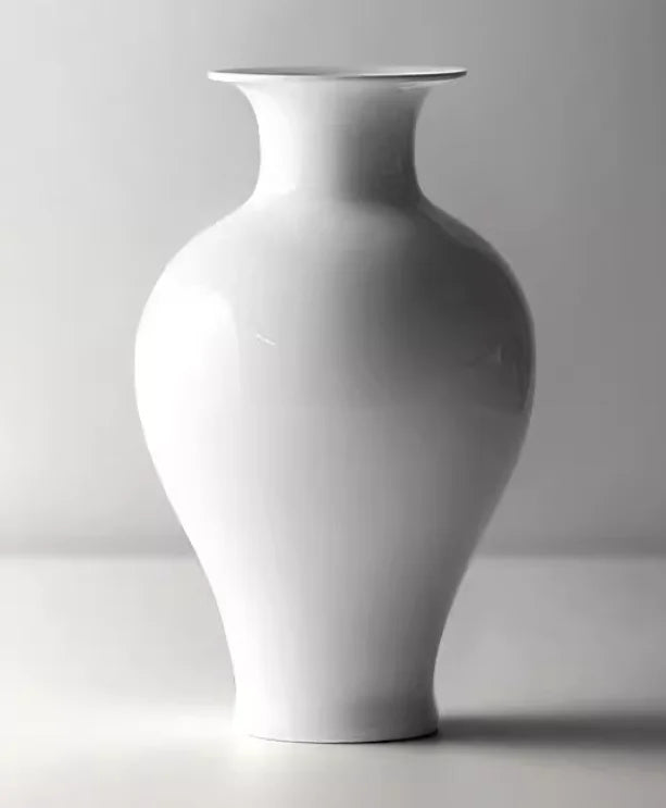 Vase de style minimaliste en céramique blanche avec un col élégamment incurvé et une forme épurée.