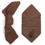 Serviette de table brun foncé avec un motif de branche verte.