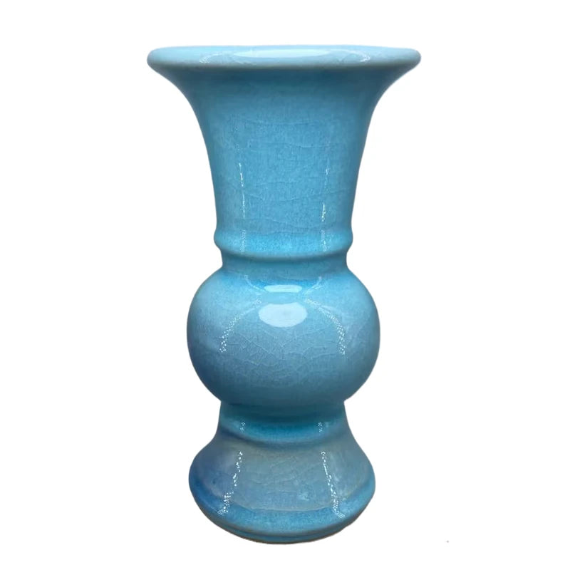 Vase décoratif en céramique brillante de couleur bleu turquoise, à la forme élégante et distinctive.