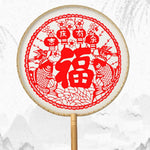 éventail artisanal traditionnel motifs floraux géométriques poignée bois pompon rouge soie tissée opacité festive
