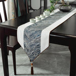 Le chemin de table décoratif en noir et blanc avec des motifs ondulés ajoute une touche élégante et moderne à cette salle à manger.