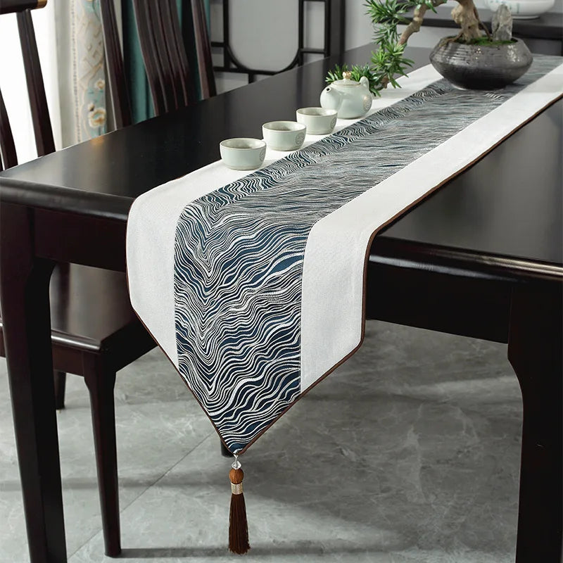 Le chemin de table décoratif en noir et blanc avec des motifs ondulés ajoute une touche élégante et moderne à cette salle à manger.