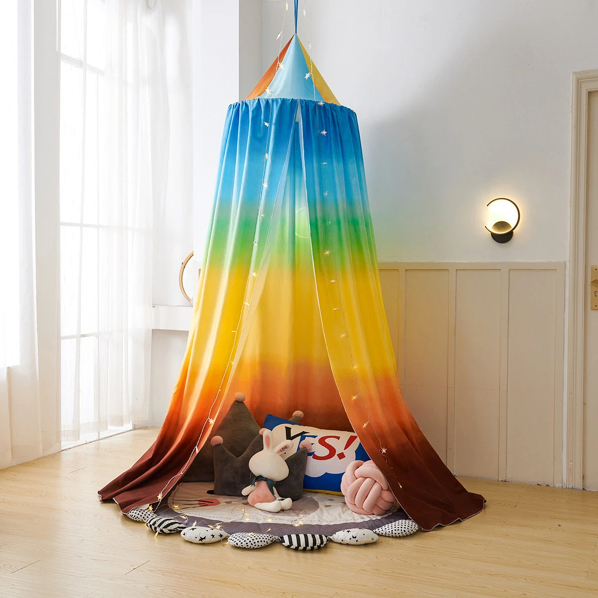 Un abri coloré et lumineux, avec des motifs étoilés, qui crée un espace de jeu et d'imagination pour un enfant.