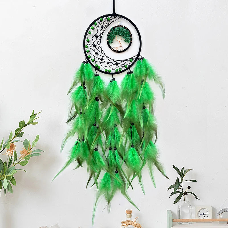 Un attrape-rêves lumineux et décoratif composé d'un cercle noir orné de motifs géométriques et de plumes vertes longilignes qui pendent gracieusement, créant une ambiance apaisante et poétique.
