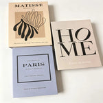 décoration minimaliste livres illustrés graphiques Paris MATISSE vase bougie fleurs séchées ruban satin clé