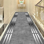 Un long tapis gris avec des rayures argentées sur le sol d'un couloir élégant.