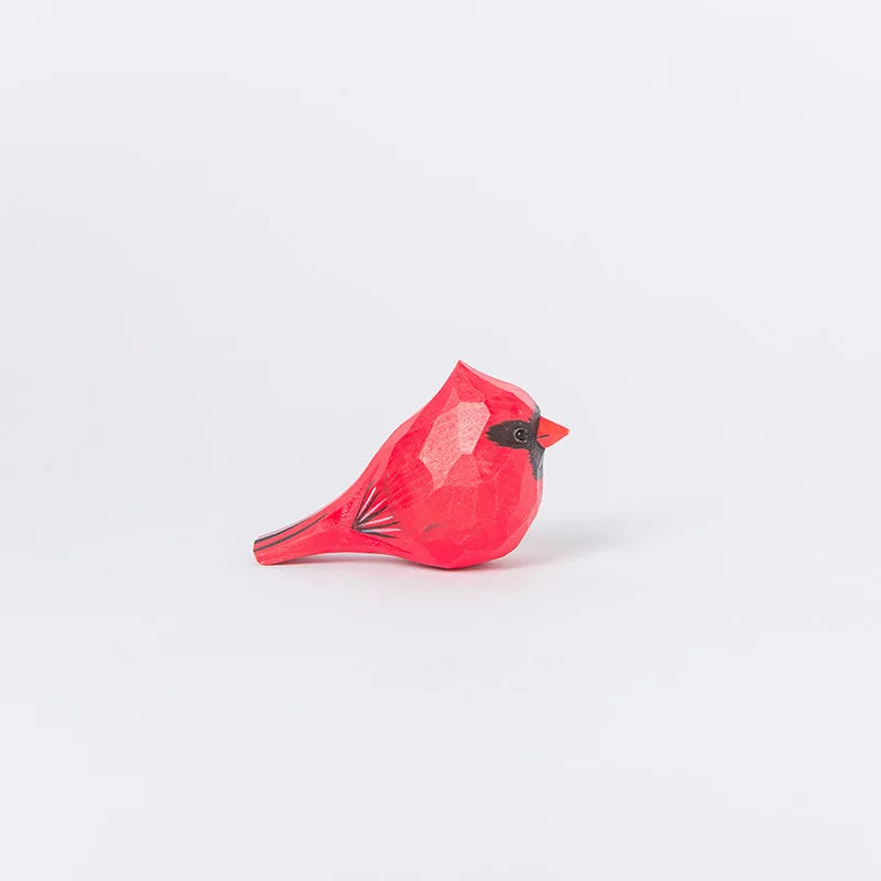 L'image montre une figurine en forme d'oiseau cardinal rouge vif, posée sur un fond blanc, avec des détails fins qui soulignent les plumes et le bec de l'animal.