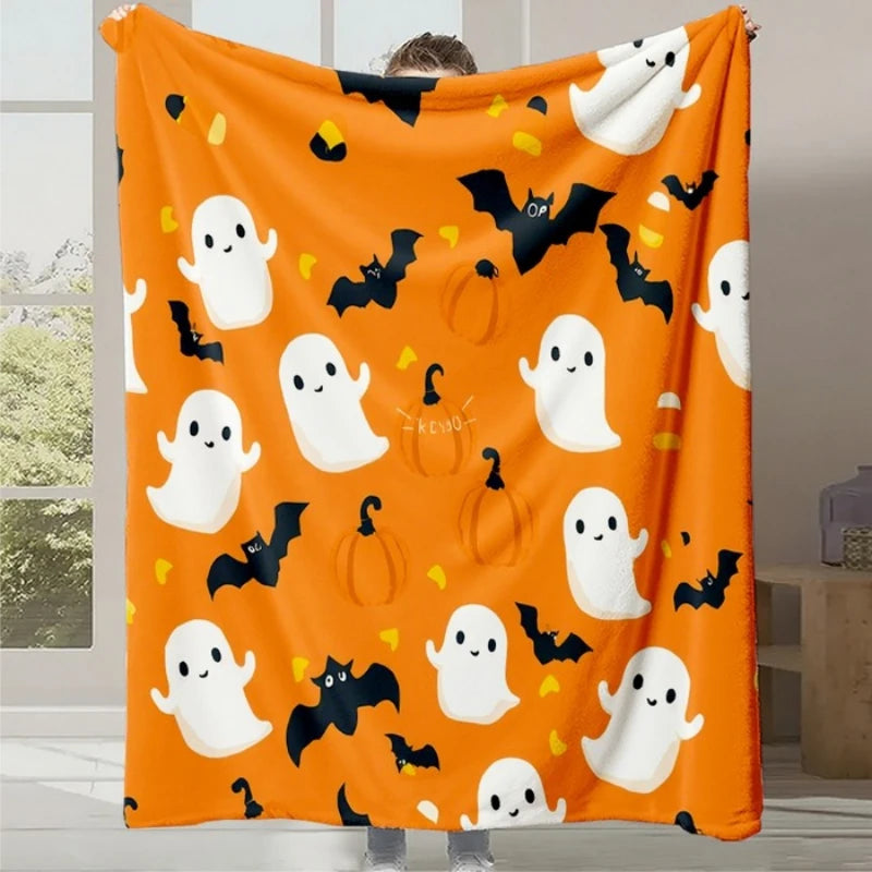Couverture orange décorée de fantômes et de chauves-souris, créant une ambiance festive et amusante pour la saison d'Halloween.