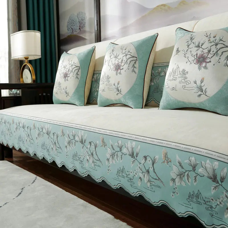 Un salon confortable avec des coussins décoratifs et des motifs floraux élégants sur le canapé.