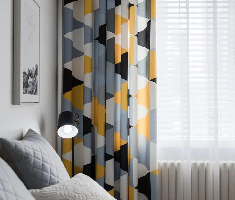 Rideaux modernes à motifs géométriques multicolores dans une chambre élégante avec une décoration minimaliste et une ambiance apaisante. Découvrez comment ces rideaux originaux ajoutent une touche de couleur et de style à votre espace, tout en optimisant la luminosité grâce à leur design artistique. Idéal pour une chambre sophistiquée et contemporaine.