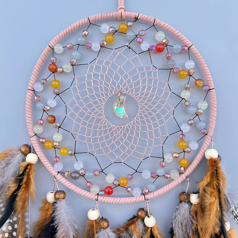 Cette image montre un magnifique capteur de rêves suspendu avec de belles perles colorées, des plumes et un pendentif brillant en son centre, créant une atmosphère apaisante et méditative.