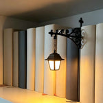 lanterne suspendue support métal forgé décoration murale motif floral panneau rectangulaire piles livres littéraire