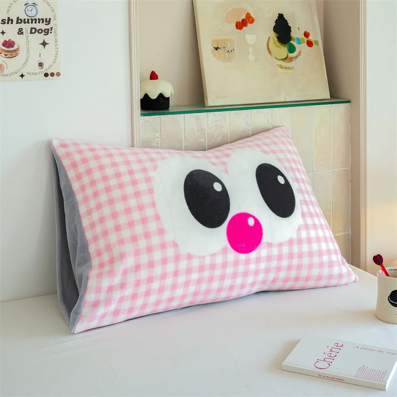 Coussin décoratif rose à motifs carreaux avec des yeux expressifs noirs et un nez rose en forme de pois, créant une apparence mignonne et ludique, parfait pour une chambre d'enfant ou un espace de détente.