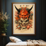 L'image représente un masque traditionnel japonais de couleur orange et noire avec des traits démoniaques et des éléments ornementaux complexes, encadré et suspendu au mur dans une pièce aux murs foncés.